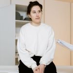 Mulher adulta participa atentamente de uma consulta médica em uma clínica.