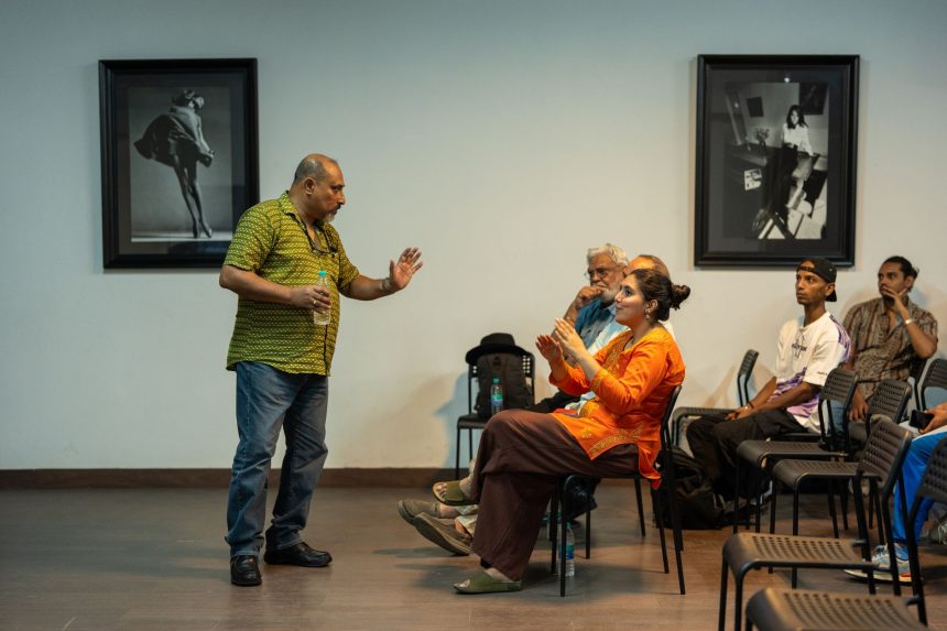 Pessoa fala ao público em uma sala de conferências durante uma discussão coletiva.