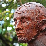 Escultura metálica em perfil, formada por peças de sucata soldadas.