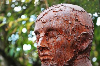 Escultura metálica em perfil, formada por peças de sucata soldadas.